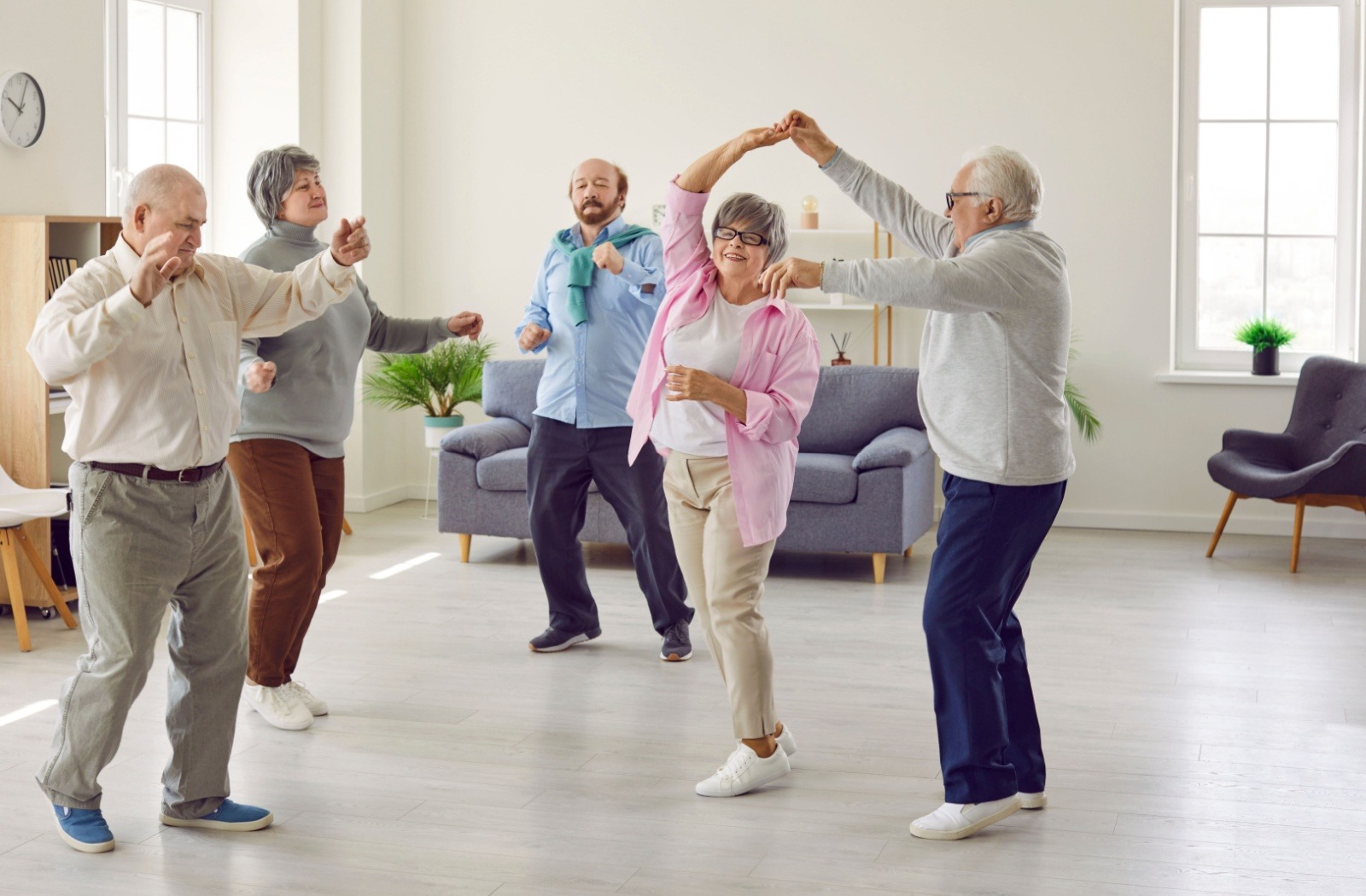 A group of seniors take a dance class at their senior living community.